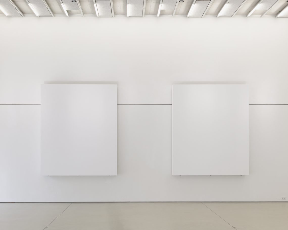 Blick auf zwei massive weiße Stellwände in der Ausstellung Landschaftsmalerei von atelier drei, Stadtgalerie Lehen 2025