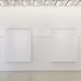 Blick auf zwei massive weiße Stellwände in der Ausstellung Landschaftsmalerei von atelier drei, Stadtgalerie Lehen 2025