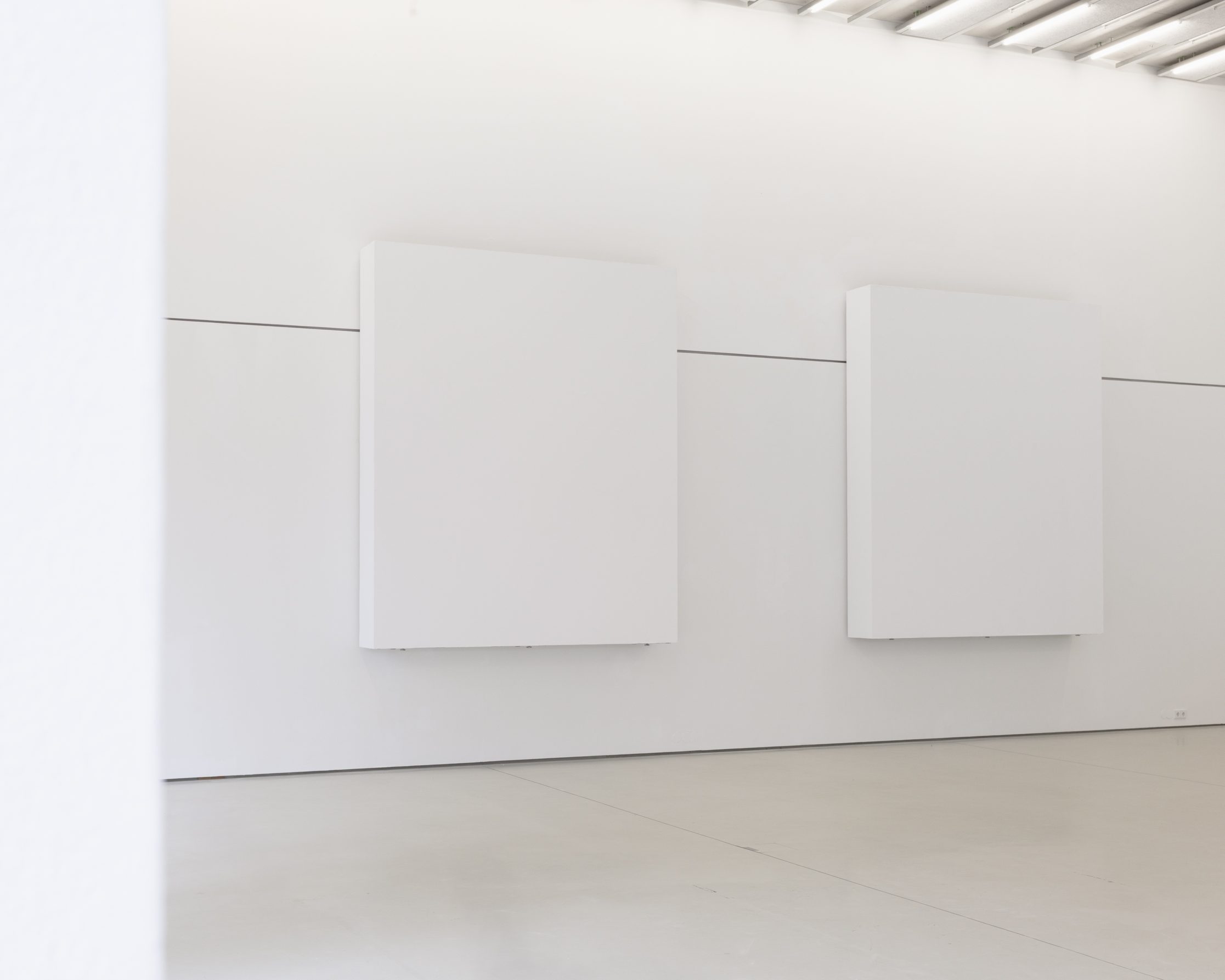 Perspektivische Ansicht der minimalistischen Ausstellung Landschaftsmalerei von atelier drei mit raumgreifenden weißen Wänden, Stadtgalerie Lehen