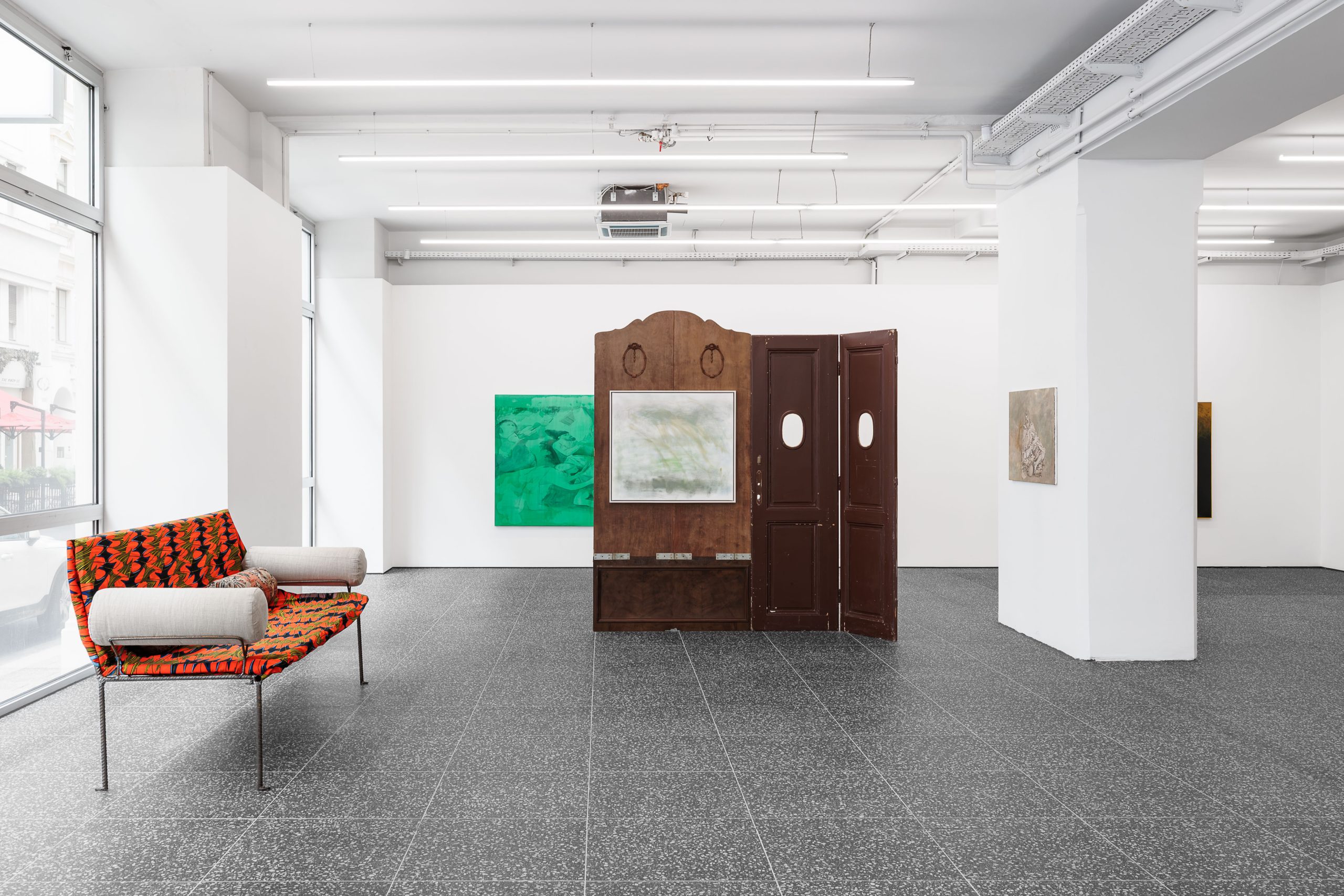 Lou von der Heyde inszeniert ein Theaterstück, in dem literarische Figuren und Kunstwerke inmitten eines bühnenbildartigen Settings aus Holztüren aufeinandertreffen.