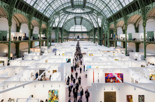 Blick von oben auf die Kunstmesse Art Basel Paris im Grand Palais: Messestände mit Gemälden unter der historischen Glas-Stahl-Kuppel, Besucher im Mittelgang