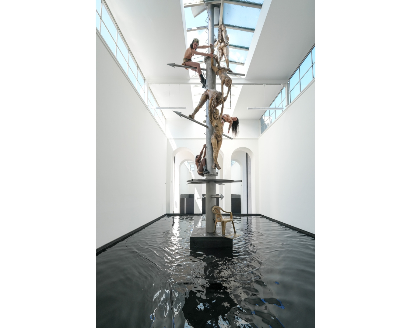 Performerinnen klettern einen Metallmast über dem Wassertank im österreichischen Pavillon bei der Biennale in Venedig
